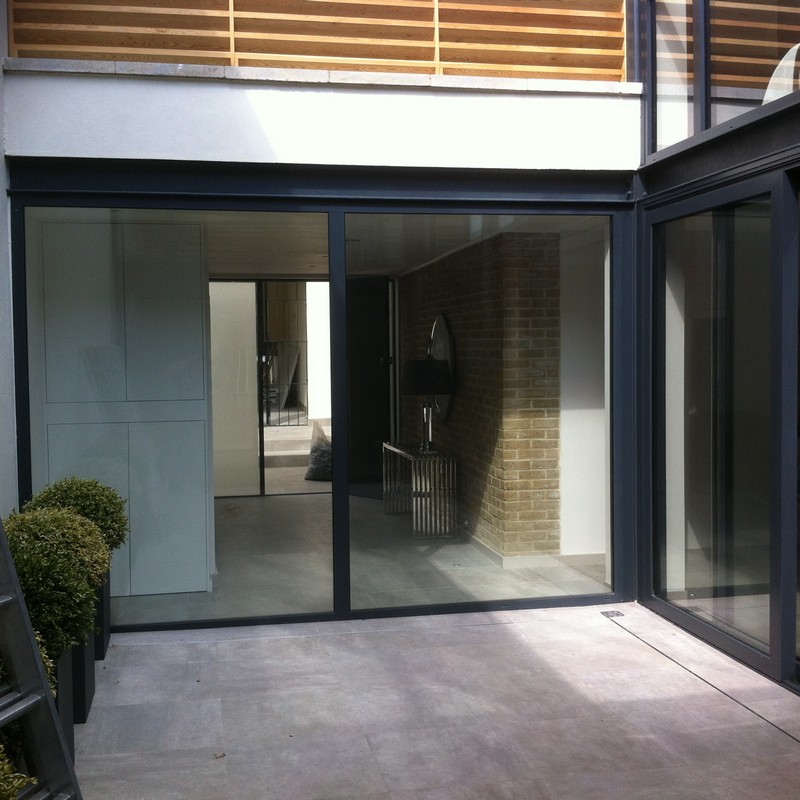 Floor-to-ceiling sliding doors opening to courtyard in Cobham