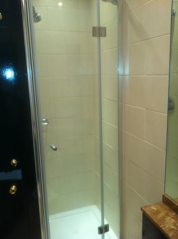 Frameless glass shower enclosure with chrome fittings in Cobham