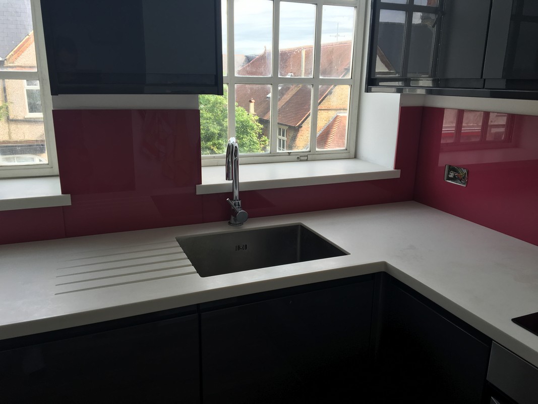 Deep plum coloured glass splashback in modern Cobham kitchen